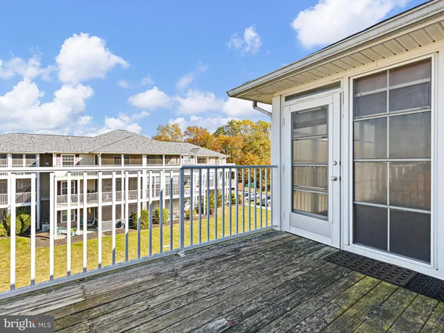 a view of a room with wooden floor fan and windows