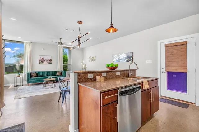 a room with stainless steel appliances kitchen island a table and chairs