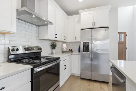 a kitchen with a refrigerator stove and cabinets