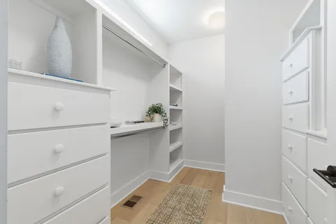 a view of walk in closet with empty racks