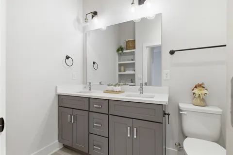 a bathroom with a toilet sink and mirror