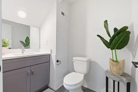 a bathroom with a toilet a sink and mirror