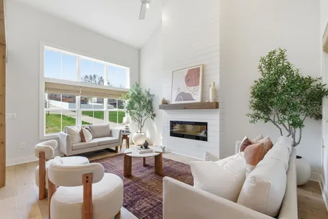 a living room with furniture a large window and a fireplace