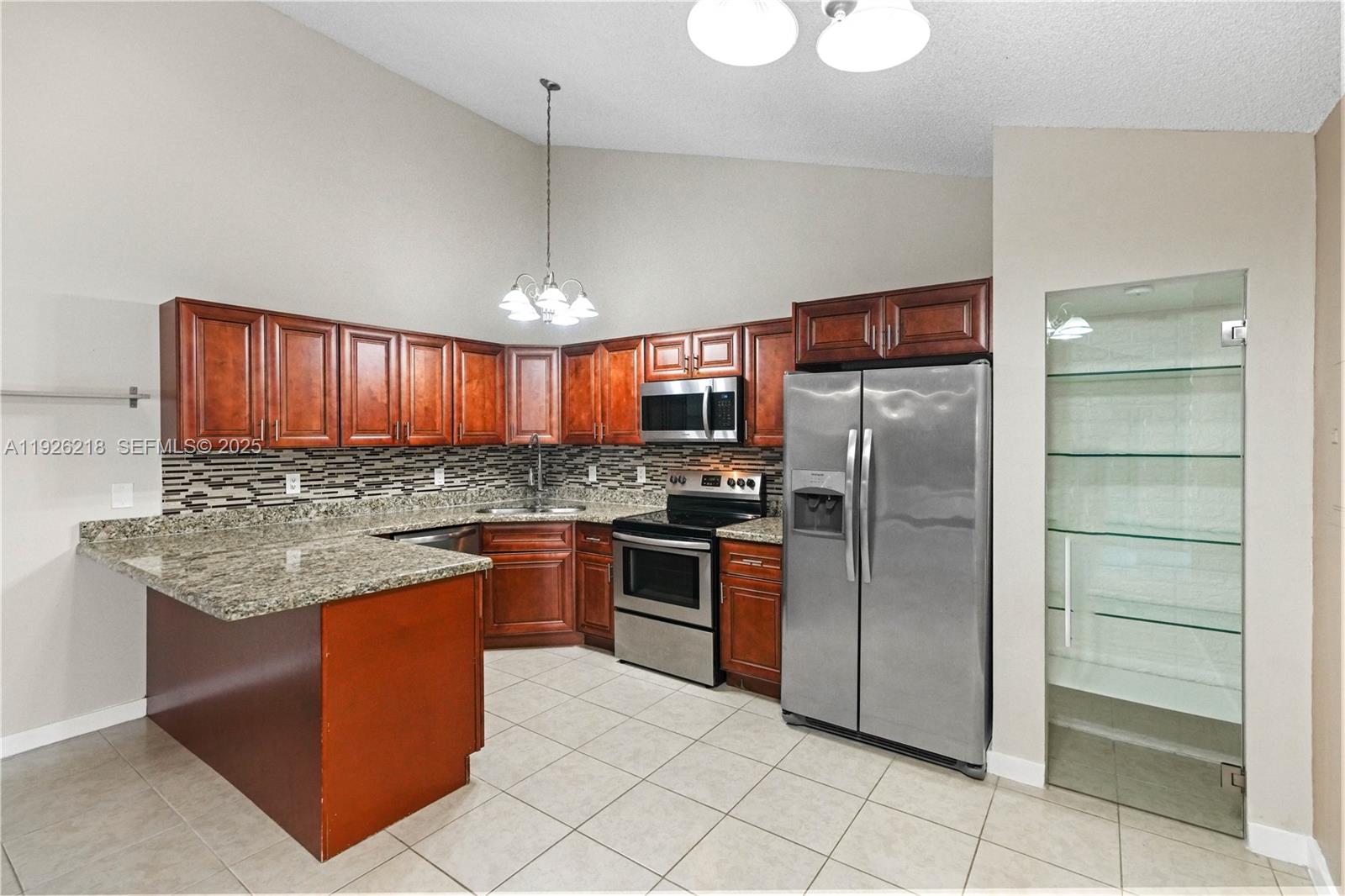 9568 Boca Gardens Parkway, Unit B Boca Raton, FL 33496 - Photo 12 of 71 a kitchen with stainless steel appliances granite countertop a stove top oven a refrigerator and a sink