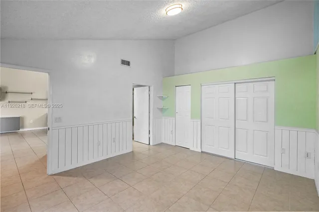 an aerial view of a house with swimming pool and large trees