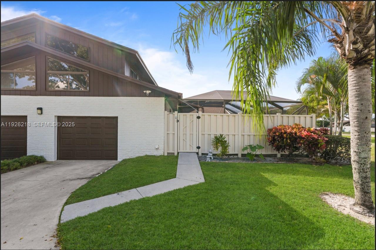9568 Boca Gardens Parkway, Unit B Boca Raton, FL 33496 - Photo 3 of 71 a front view of a house with a garden and yard