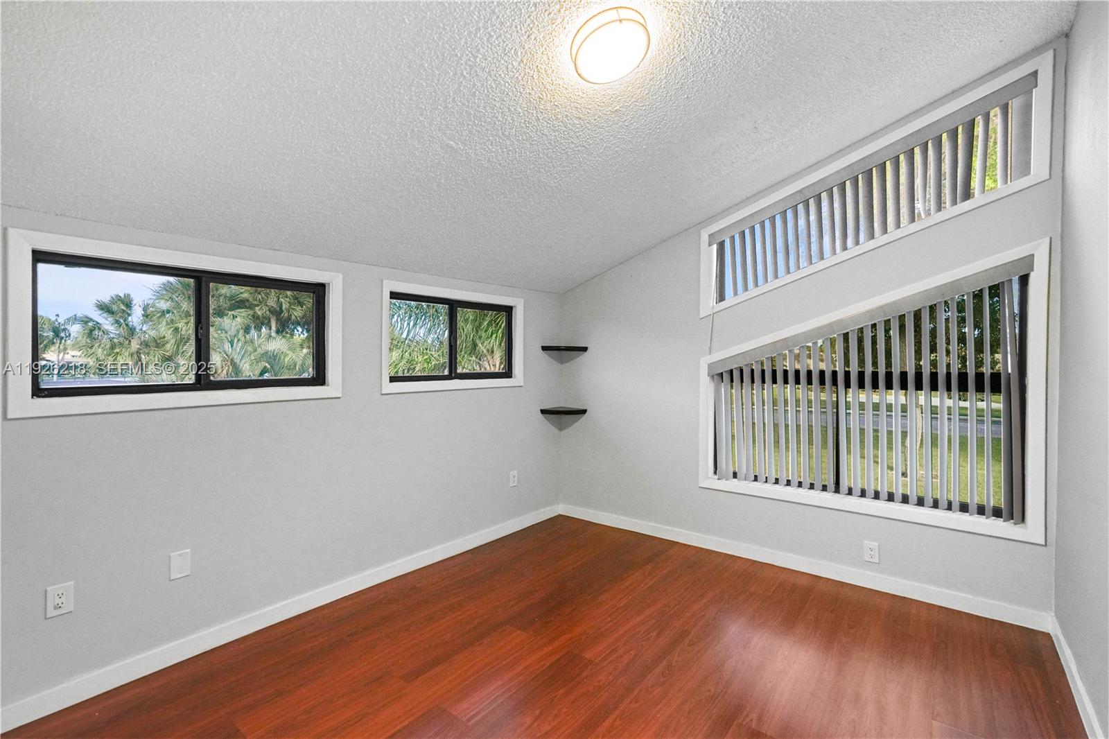 9568 Boca Gardens Parkway, Unit B Boca Raton, FL 33496 - Photo 35 of 71 a view of an empty room with wooden floor and a window