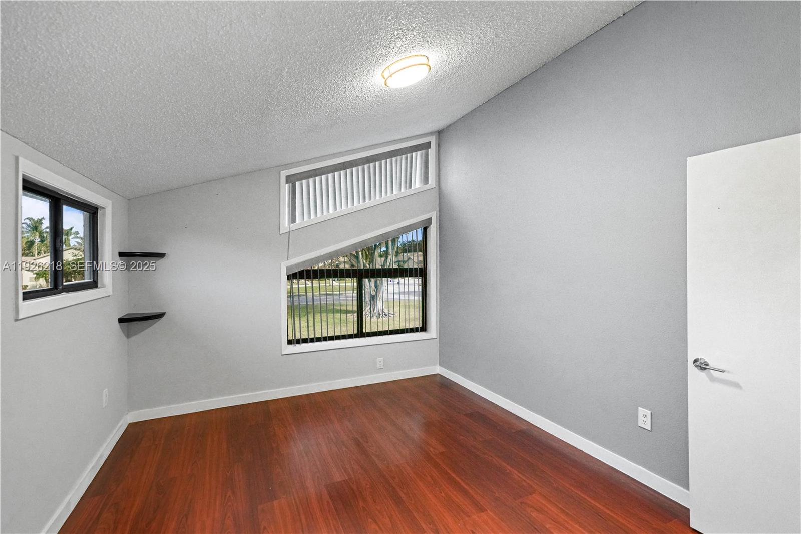 9568 Boca Gardens Parkway, Unit B Boca Raton, FL 33496 - Photo 38 of 71 an empty room with wooden floor and windows