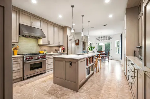 a kitchen with stainless steel appliances granite countertop a stove a sink dishwasher a refrigerator and a oven with wooden floor