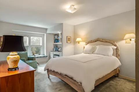 a bedroom with a bed and large window