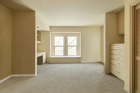 an empty room with windows and closet