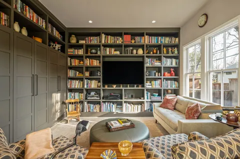 a living room with furniture a rug and a book shelf