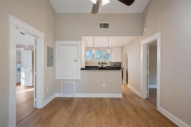 a view of a kitchen with a refrigerator wooden floor and a window