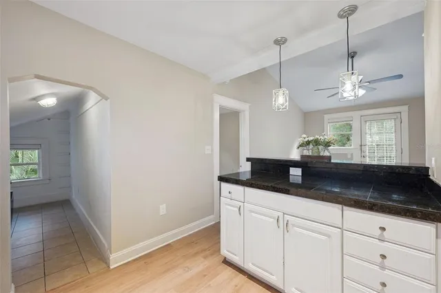 a kitchen with granite countertop a sink a counter space and cabinets