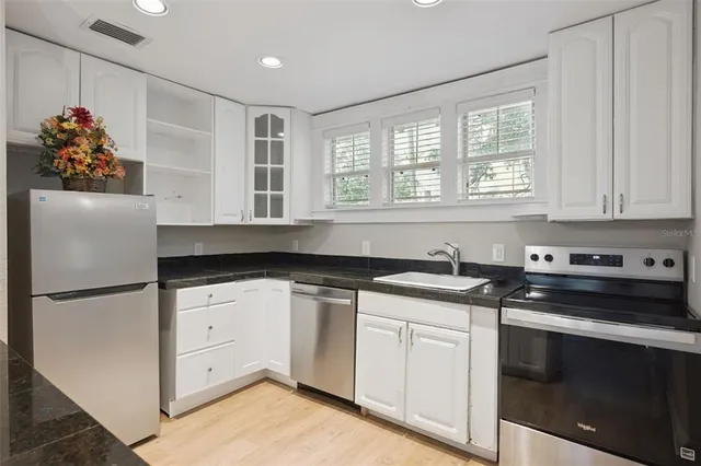 a kitchen with stainless steel appliances granite countertop a sink stove and refrigerator