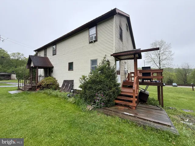 a view of a house with backyard and chairs
