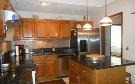 97030 Pirates Point Road Yulee, FL 32097 - Photo 4 of 24 a kitchen with stainless steel appliances granite countertop a sink and cabinets