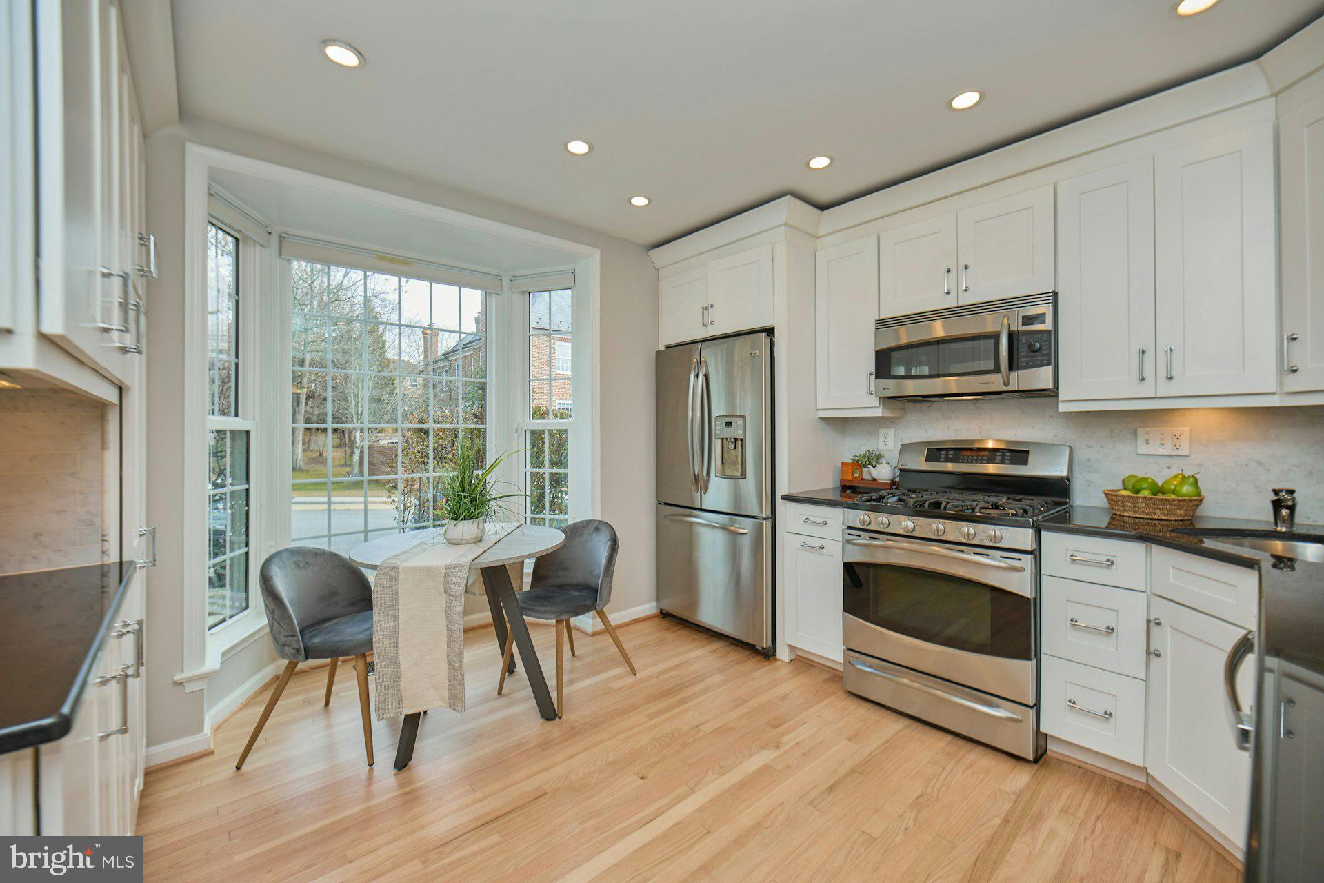 1120 Kensington Road McLean, VA 22101 - Photo 7 of 47 a kitchen with stainless steel appliances granite countertop a stove a refrigerator a sink a dining table and chairs