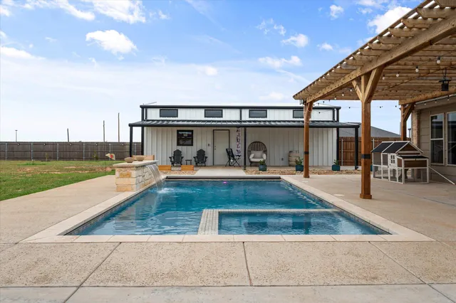 a view of a backyard with swimming pool