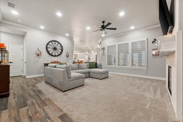 a large white kitchen with wooden floor and a fireplace