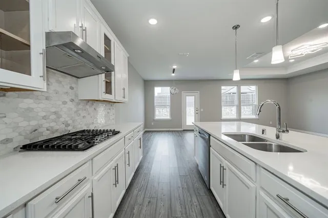 a kitchen with stainless steel appliances granite countertop a sink stove and cabinets