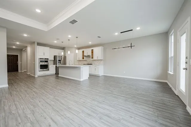 a view of a kitchen with a refrigerator and a stove top oven