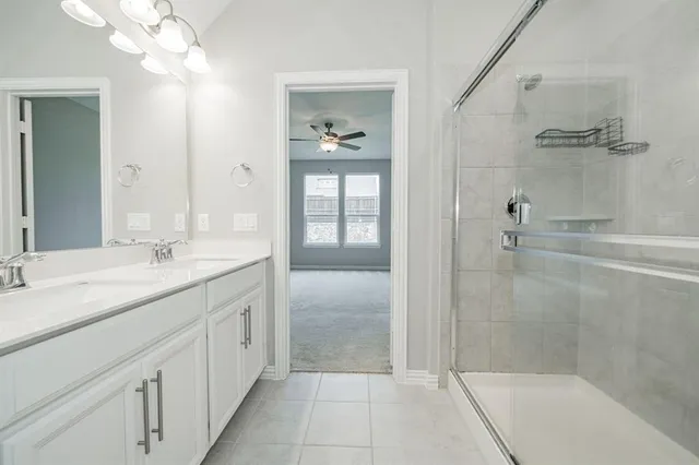 a bathroom with a granite countertop sink a mirror and shower