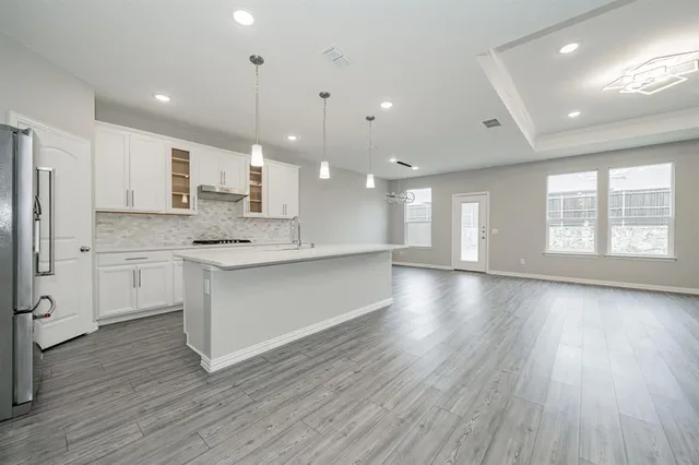 a view of kitchen with granite countertop stainless steel appliances refrigerator sink and cabinets