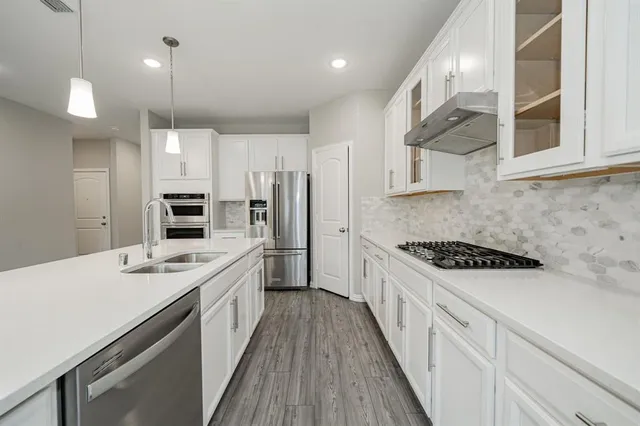 a kitchen with stainless steel appliances a sink stove and refrigerator