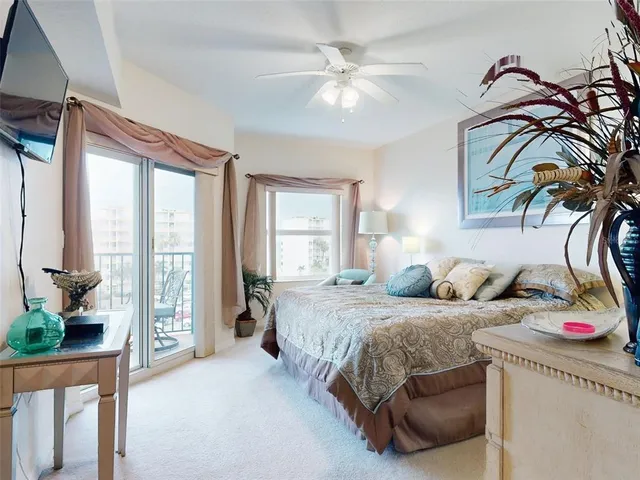 a bedroom with a bed a mirror on dresser and a chandelier