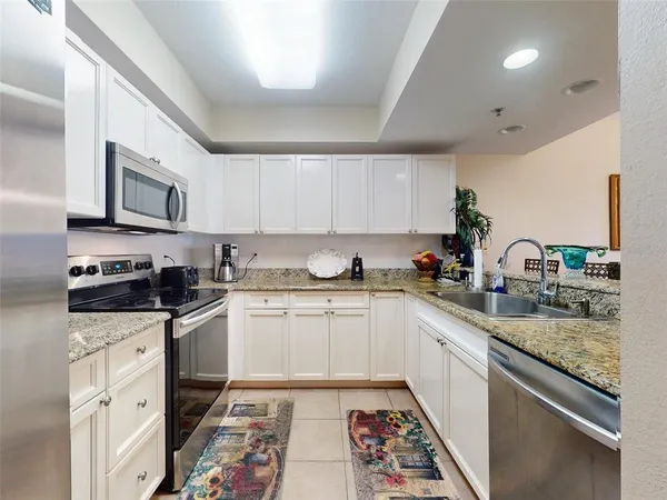 a kitchen with cabinets stainless steel appliances and a counter space