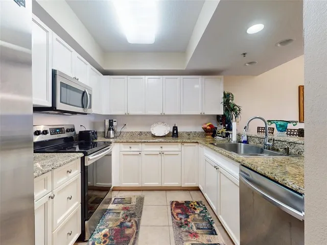 a kitchen with cabinets stainless steel appliances and a counter space