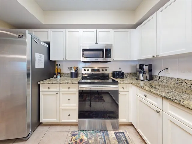 a kitchen with stainless steel appliances granite countertop a sink cabinets and wooden floor