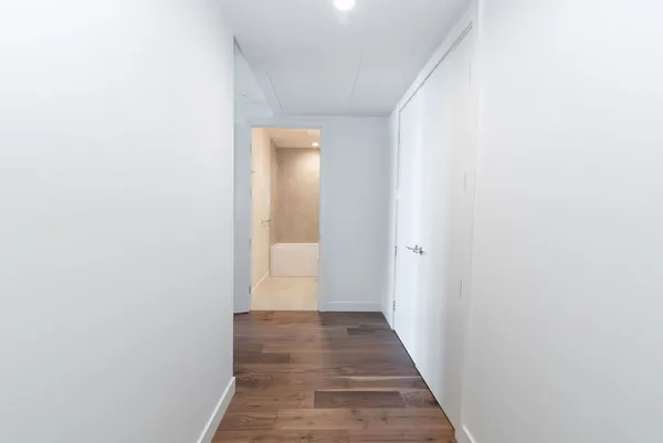 a view of a hallway with wooden floor