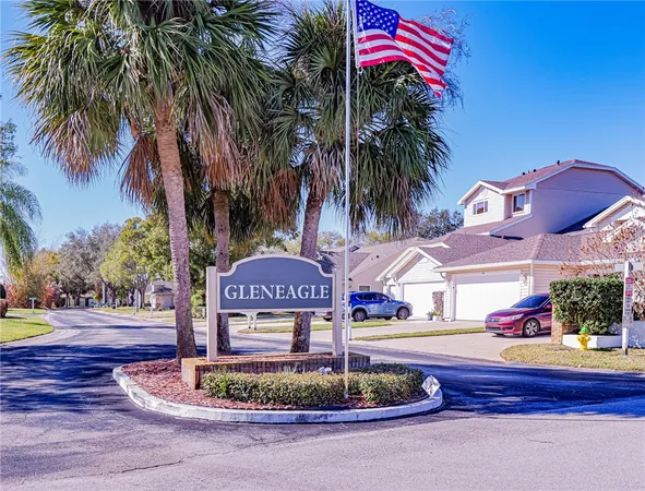 a front view of multi story residential apartment building with yard and sign board