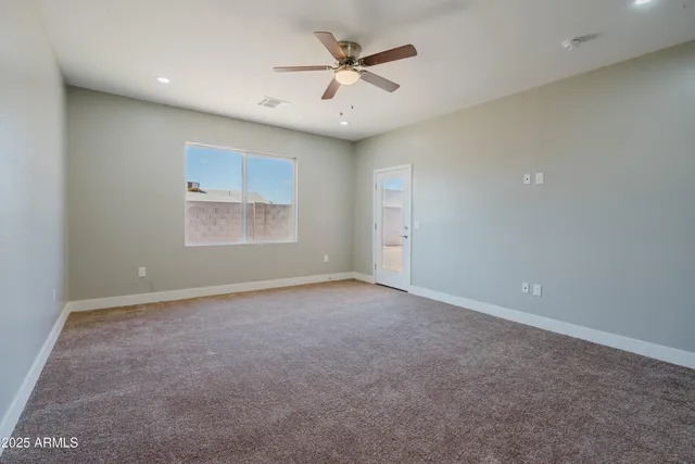 an empty room with closet and ceiling fan