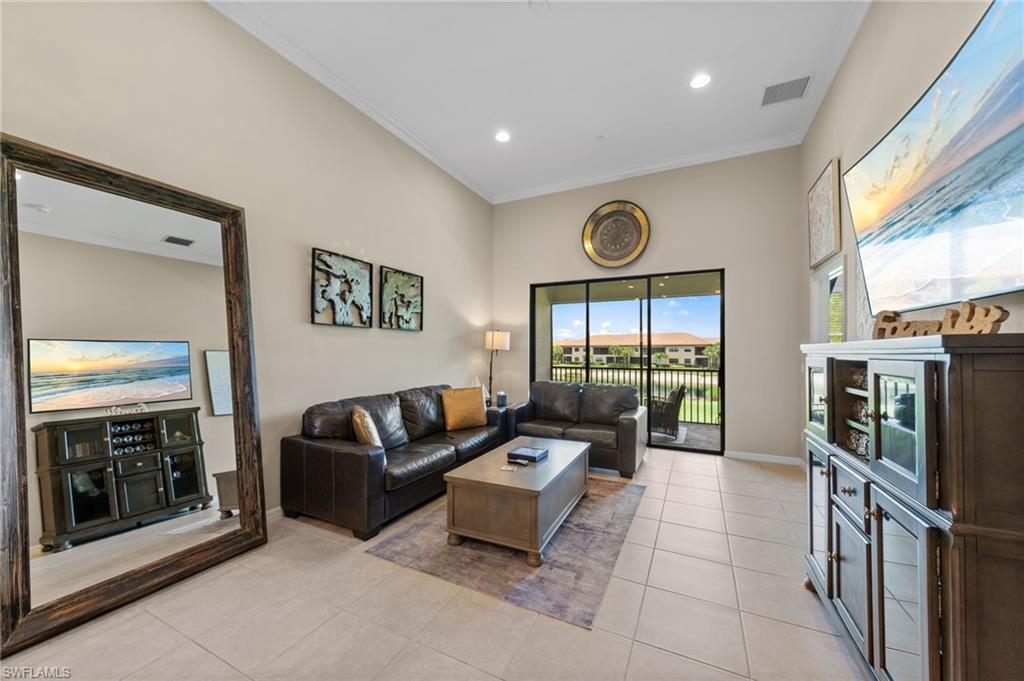 9366 Pocida Court, Unit 202 Naples, FL 34119 - Photo 5 of 44 a living room with furniture a fireplace and a large window