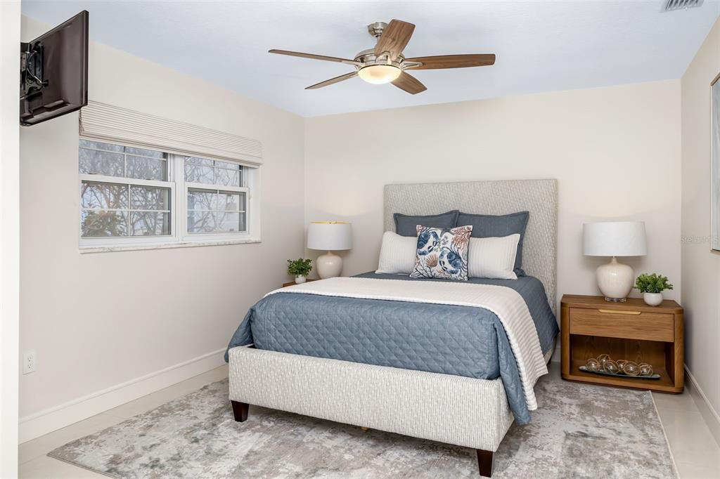 480 Cleveland Drive Sarasota, FL 34236 - Photo 38 of 95 a bedroom with a bed a couch and a flat tv screen on the dresser