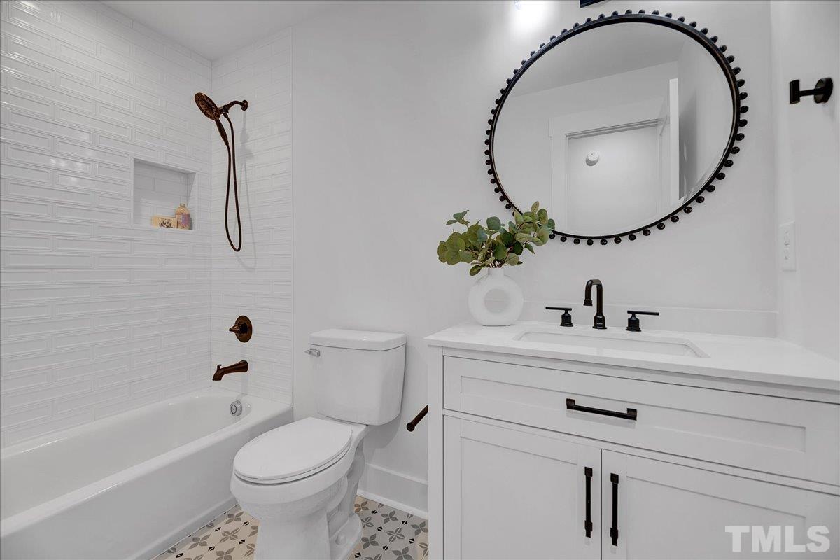 1108 East Millbrook Road Raleigh, NC 27609 - Photo 24 of 43 a bathroom with a sink a toilet and a mirror