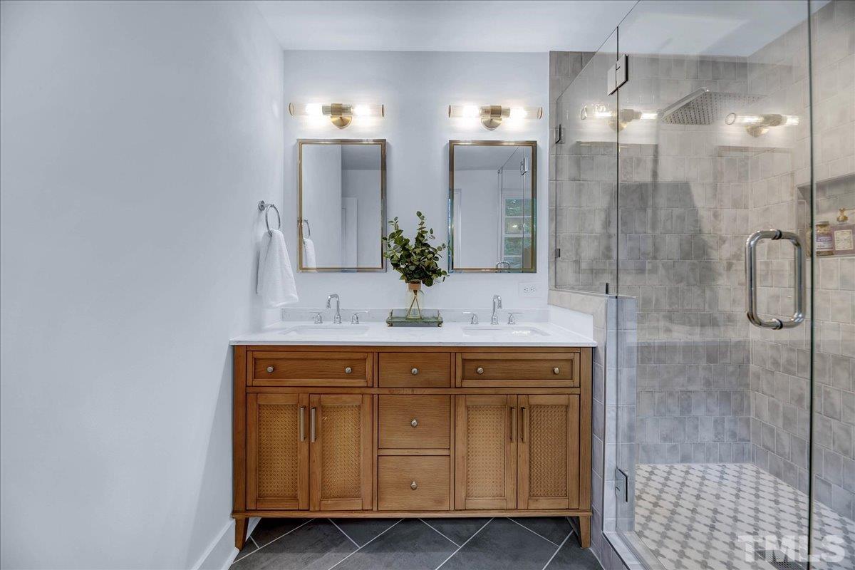 1108 East Millbrook Road Raleigh, NC 27609 - Photo 38 of 43 a bathroom with a double vanity sink mirror and shower