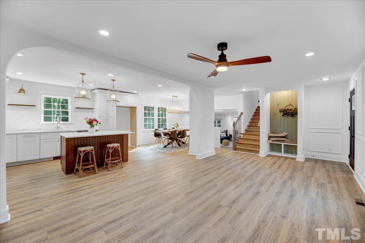 1108 East Millbrook Road Raleigh, NC 27609 - Photo 7 of 43 a view of a room with wooden floor and a ceiling fan