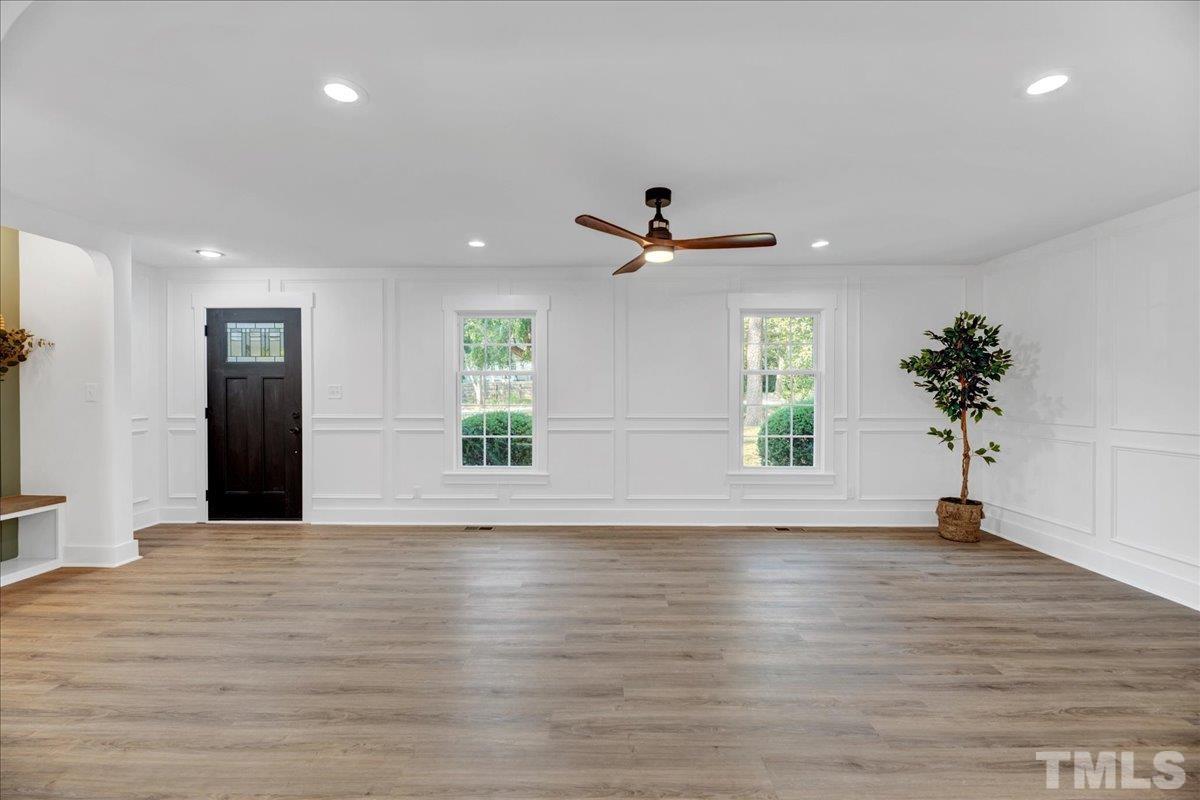 1108 East Millbrook Road Raleigh, NC 27609 - Photo 8 of 43 a view of an empty room with window and wooden floor