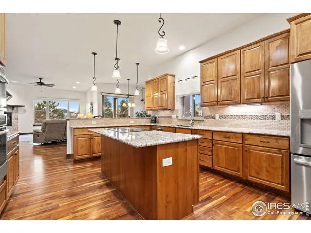 a kitchen with stainless steel appliances granite countertop a sink stove and wooden cabinets
