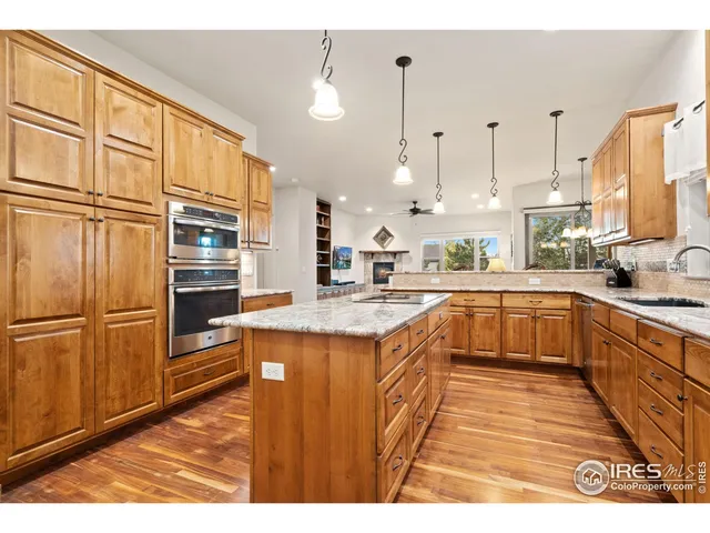 a large kitchen with stainless steel appliances granite countertop a stove a sink and a refrigerator
