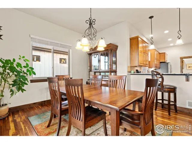a dining room filled chandelier and wooden floor