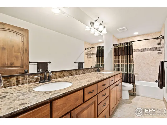 a bathroom with a granite countertop sink a large mirror and a shower