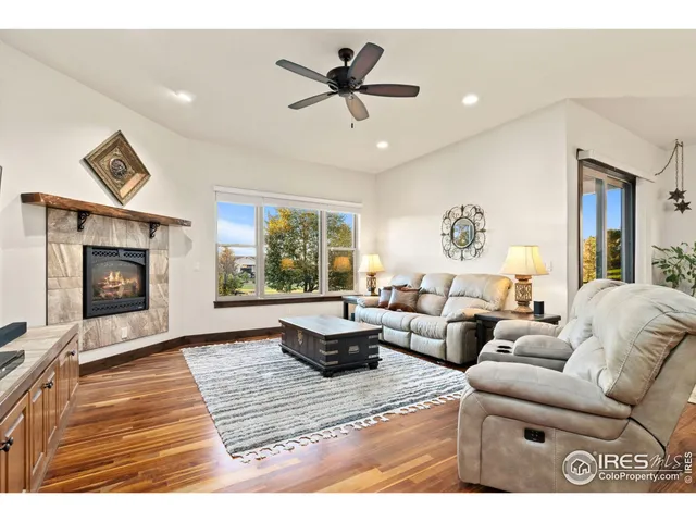 a living room with furniture a large window and a fireplace