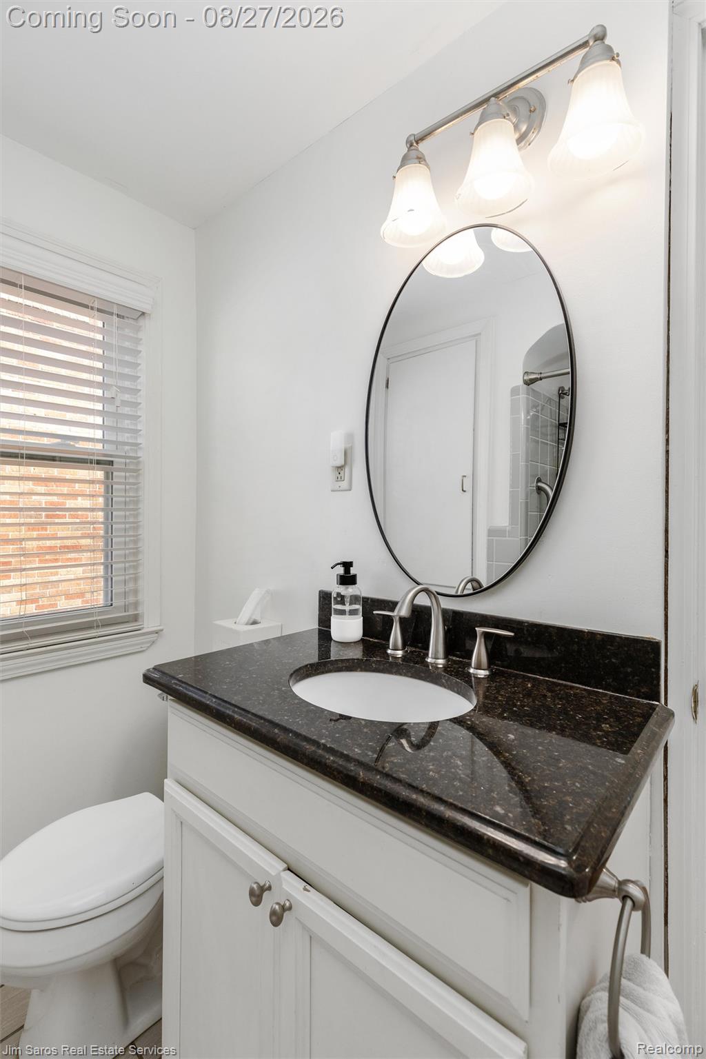 276 Moran Road Grosse Pointe, MI 48236 - Photo 14 of 23 White vanity cabinet with dark countertop, undermount sink, and brushed nickel fixtures