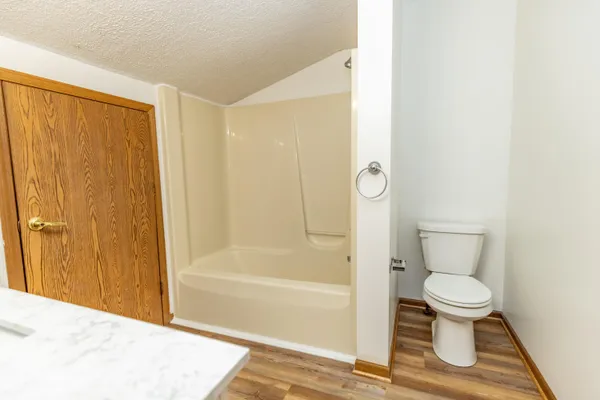 an empty room with a chandelier fan and windows