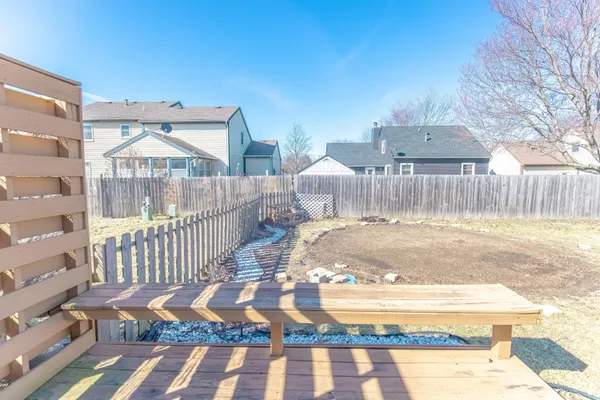 a view of a chair and table with wooden fence